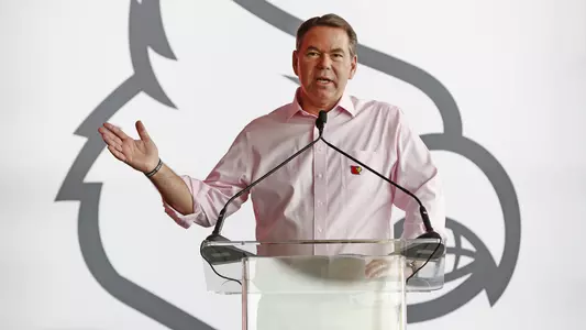 UofL Director of Athletics Vince Tyra addresses a crowd from the podium at a recent event.