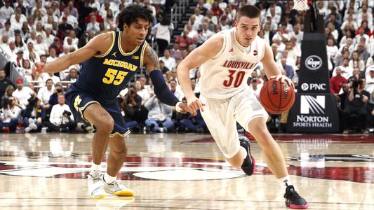 Ryan McMahon drives against No. 4 Michigan in the Cardinals' 58-43 victory.