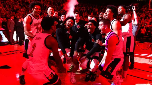 UofL's men's basketball team gathers funder the red lights ollowing pregame introductions in the KFC Yum! Center.