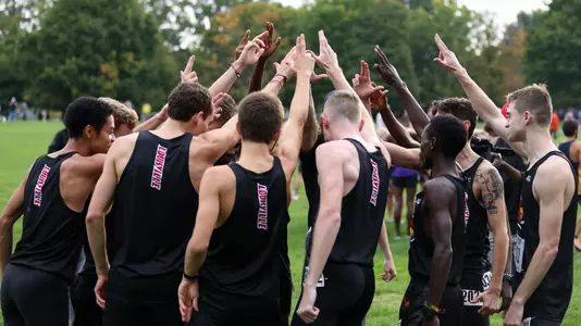 Men's Cross Country huddles before Live in Lou