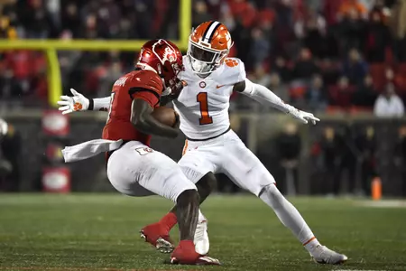 Louisville quarterback Malik Cunningham, left, is grabbed by Clemson safety Andrew Mukuba (1) during the second half of an NCAA college football game in Louisville, Ky., Saturday, Nov. 6, 2021. (AP Photo/Timothy D. Easley)