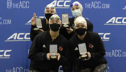 The 200 Free Relay team poses on the podium with their medals.