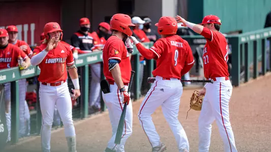 The Cardinals celebrate after scoring a run at NC State.
