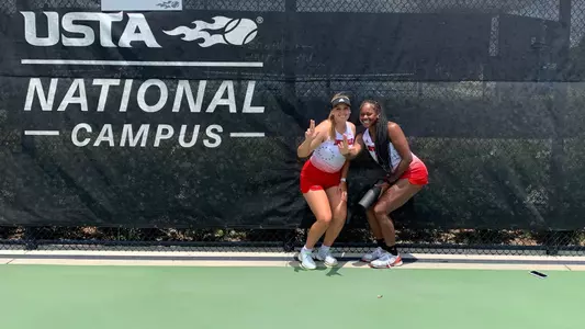 tatiana simova and raven neely pose in front of NCAA Sign