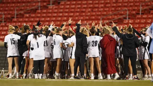 Lacrosse team huddle at Cardinal Stadium.