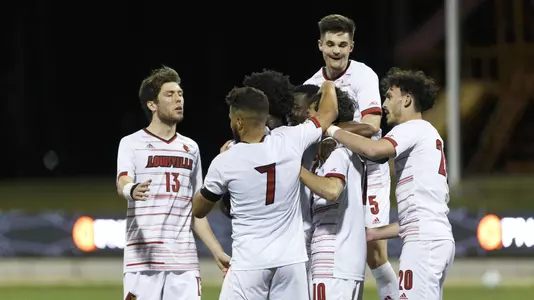 Men's soccer celebrates a goal.