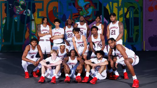 The 2022-23 Louisville men's basketball team poses in front of a West End mural for their schedule poster shoot.