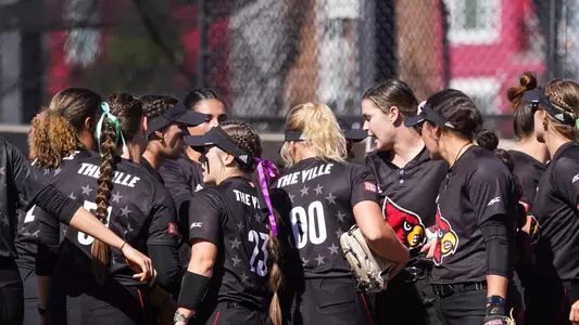 The Louisville softball team huddles before a fall exhibition game against Kentucky