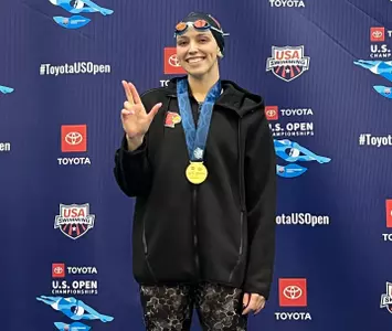Gabi Wins Gold at US Open and shows off her gold medal on the podium.