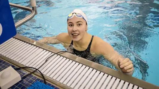 Arina Openysheva smiles at the crowd from the blocks