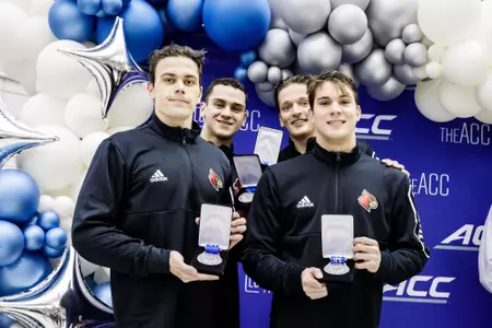 The men's 800 free relay team poses with silver medals