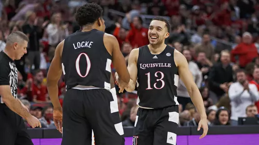 Jarrod West (right) celebrates with Noah Locke after hitting a three pointer during the game against Clemson in the KFC Yum! Center.