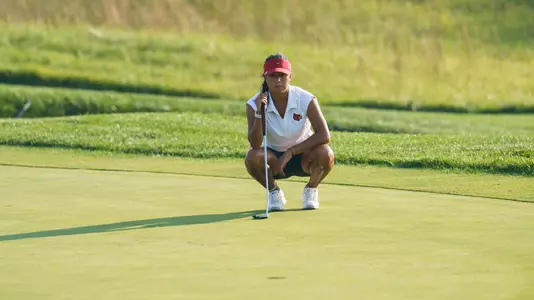 Gabbi Bentancourt squats to line up putt