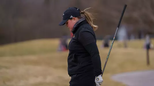 Mairead Martin walks toward her golf bag