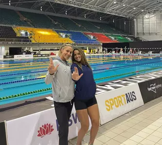 GAbi Albiero and Mallory Comerford pose poolside in Australia