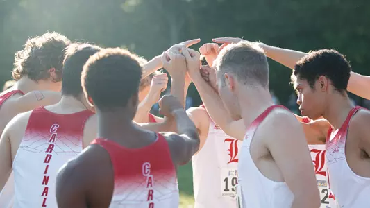 The men's team huddles before the start of the Live in Lou Classic.