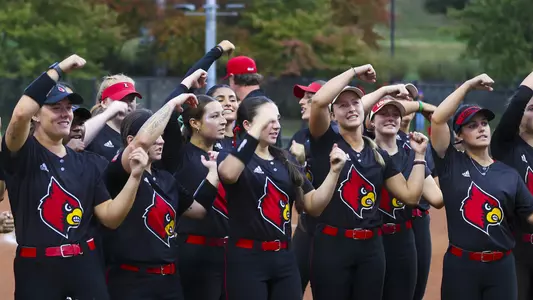 The softball team participates in the CARDS cheer following a fall softball game