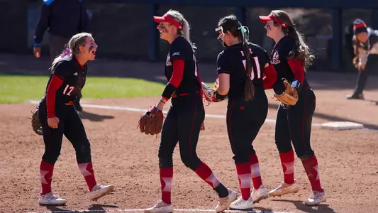 The softball team celebrates after an out against Illinois
