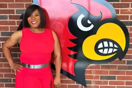 Sheryl Knight poses by Cardinal sign