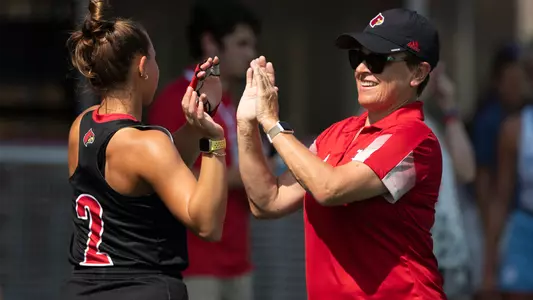 Head coach Justine Sowry high-fives Sofia Pendolino before the game against North Carolina