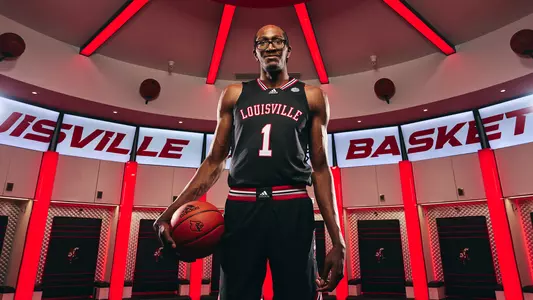 New Louisville men's basketball signee Dennis Evans poses in the locker room.