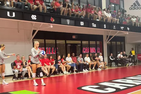 Anna DeBeer serving in front of the courtside seats