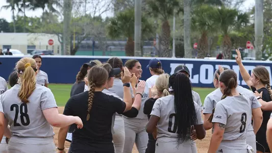 Louisville softball celebrates the 2-0 win over Michigan