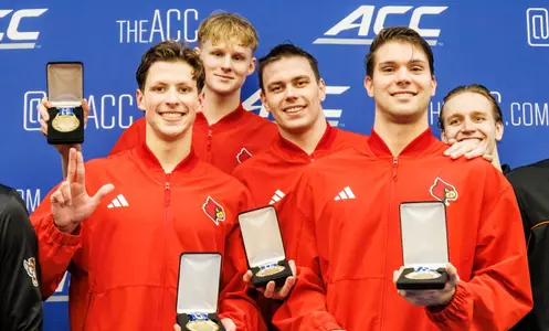 The men's 800 free relay team shows off their gold medals on the podium
