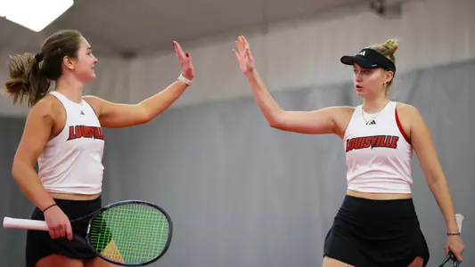 Alice Otis and Elisabeth Iila high five after doubles point