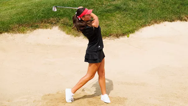 Veronika Exposito swings in the sand trap