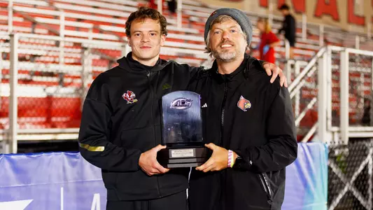 Roman Kuleshov and Bob Thurnhoffer pose with Kuleshov's Men's Field MVP trophy at the 2026 ACC Outdoor Championships.