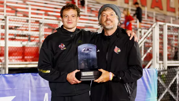 Roman Kuleshov and Bob Thurnhoffer pose with Kuleshov's Men's Field MVP trophy at the 2026 ACC Outdoor Championships.