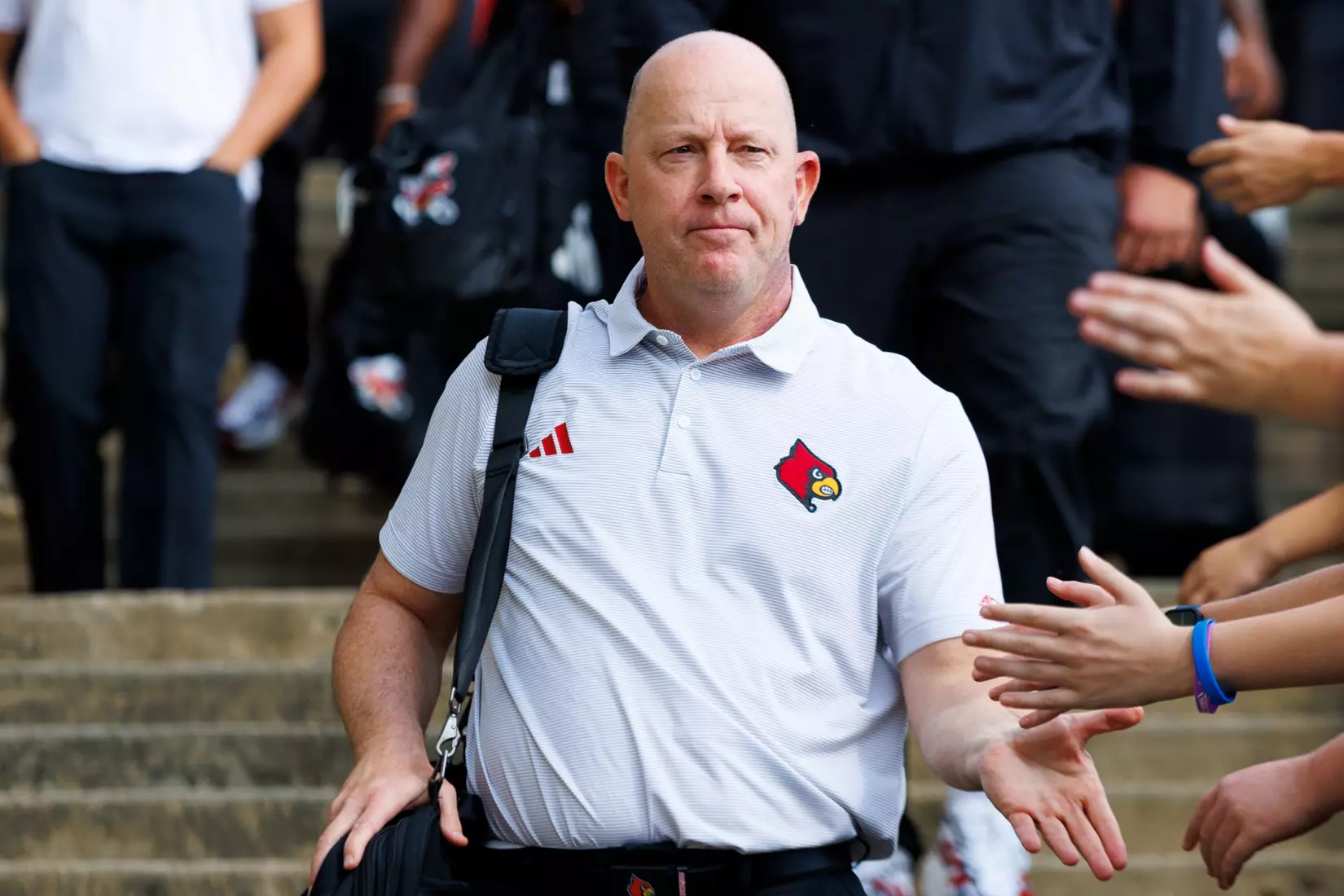 Jeff Brohm high-fives fans during the Card March before the game against Villanova at L&N Stadium on September 11.