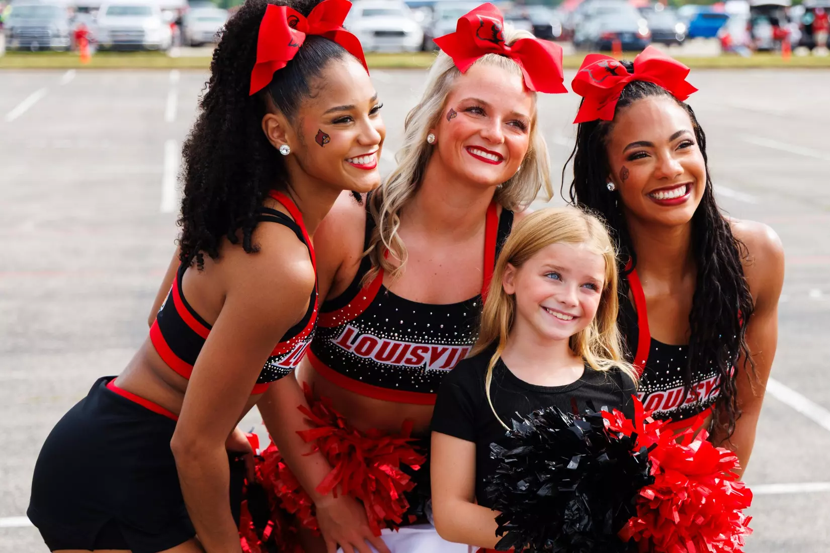 Louisville Cheerleaders pose for a photo with a fan before the game against Villanova at the L&N Stadium on September 11.