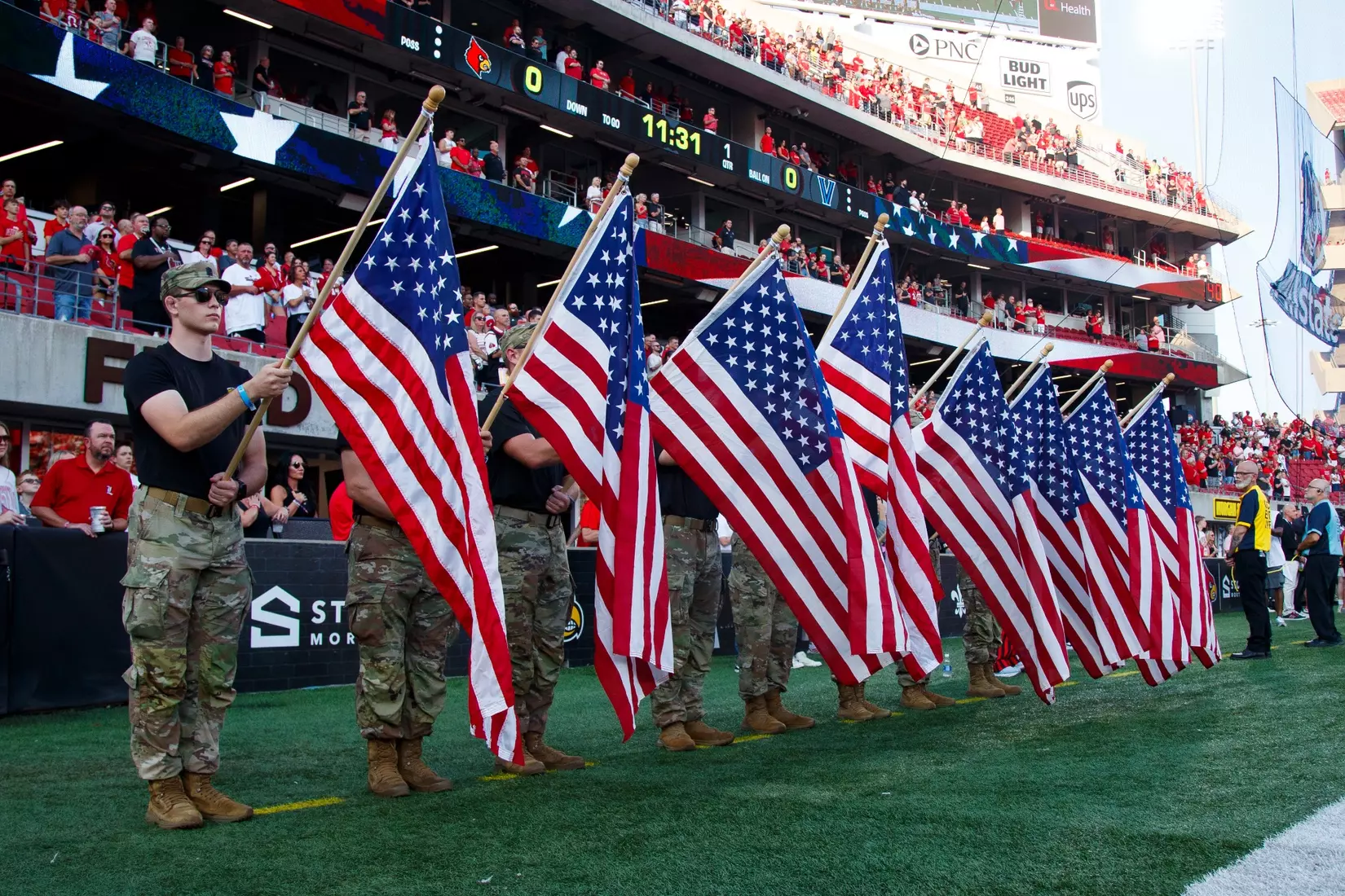 Military members hold flags during a 9/11 tribute before the game against Villanova at L&N Stadium on September 11.