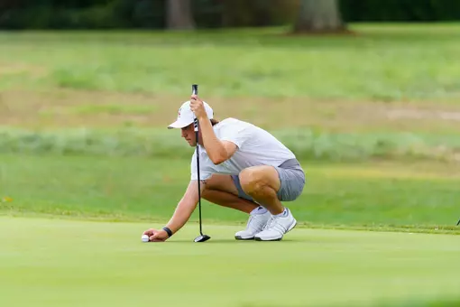 Warren Thomis lining up the golf ball for a putt.