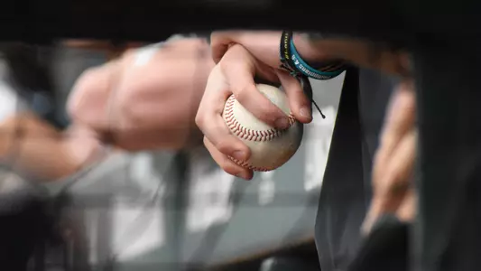 baseball in hand in dugout