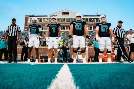 Coastal captains Zac Elam, Nick Del Grande, Dre Pinckney and Shane Bruce line up together before CSU game