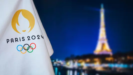 PARIS, FRANCE, AUGUST 8. 2022: Summer olympic game Paris 2024 black background. Official logo of SOG 2024 in Paris on white blanket with dark City in night. Black edit space, sport event
