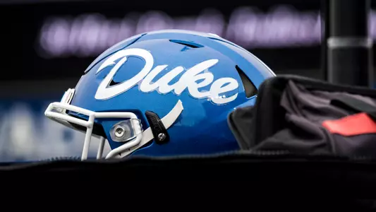 A Duke football helmet sits on top of a truck during a game