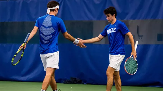 Sean Sculley and Garrett Johns celebrate after earning a point in doubles action