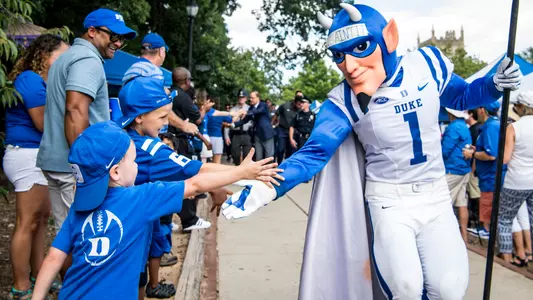 The Blue Devil interacts with young Duke fans during the Blue Devil Walk
