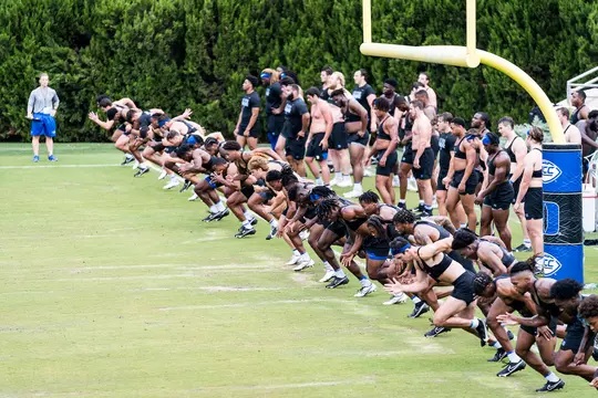 Members of the Duke football team run during a summer 2022 practice.