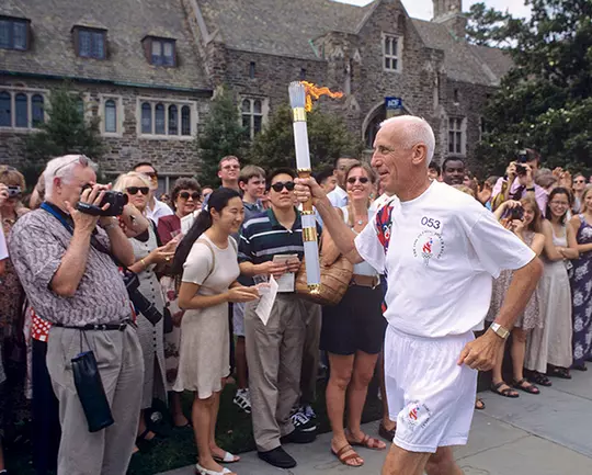 Al Buehler carries the Olympic torch through Duke's campus