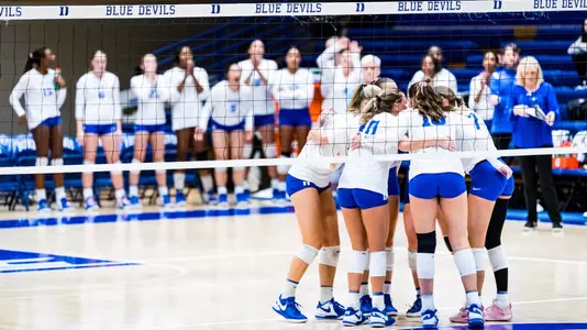 Duke volleyball huddles during a game at Cameron Indoor Stadium