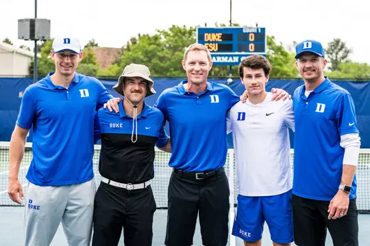 Senior Garrett Johns poses with the Duke men's tennis coaching staff on Senior Day at Ambler Tennis Stadium.