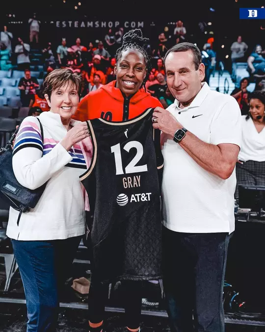 Coach K and Mickie Krzyzewski pose with former Blue Devil Chelsea Gray while holding her WNBA jersey.