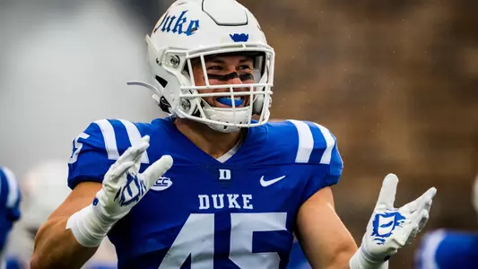 Ozzie Nicholas smiles and claps his hands during a Duke football game.