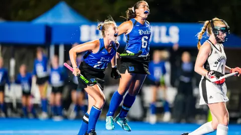 Paige Bitting and Macy Szukics celebrate a goal against Louisville field hockey