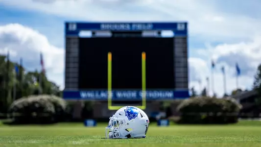 A white Duke football helmet with a blue hellraiser logo sits on the ground in front of the video board inside Brooks Field at Wallace Wade Stadium.